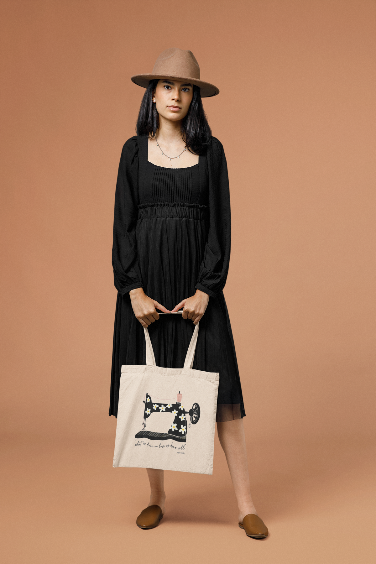 Mockup of a woman in a dark dress posing with the Done In Love tote bag