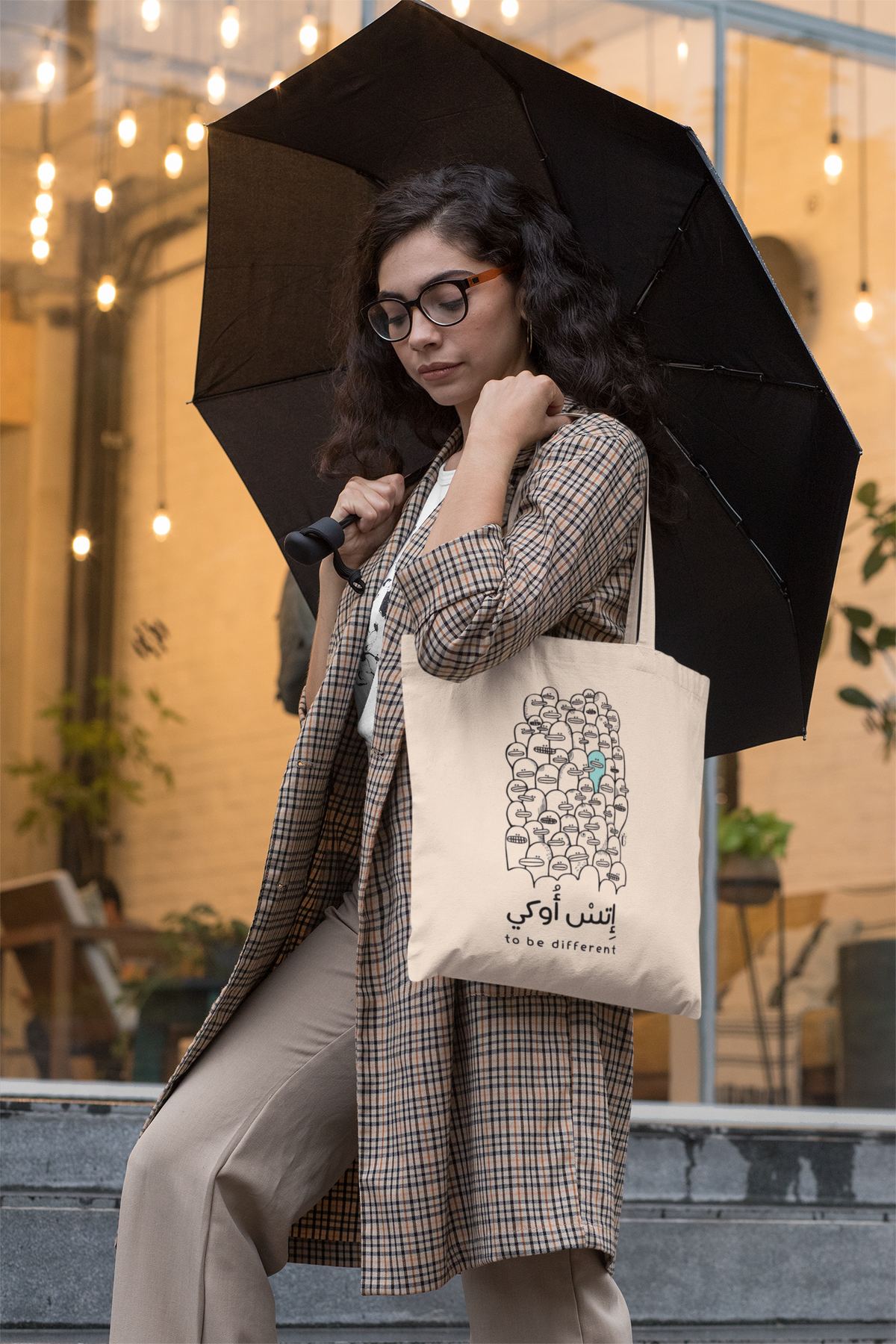 Mockup of a woman carrying the It's Okay To Be Different tote bag by Giftolla