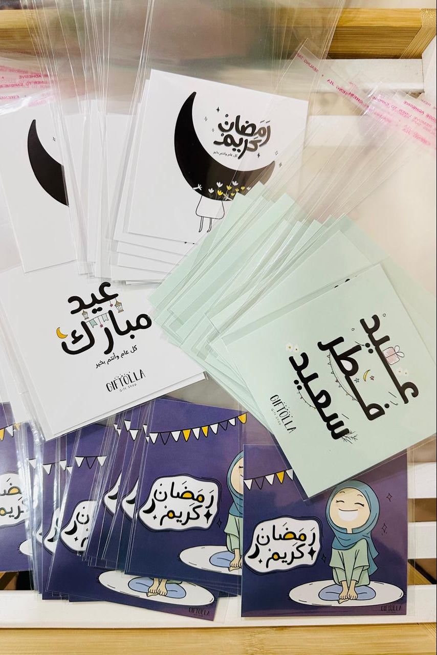 Collection of cards with Arabic text and illustrations on a wooden surface